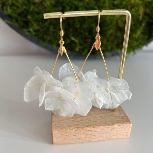 Boucles d'oreilles Manu forme ovale dorée avec de l'hortensia blanc