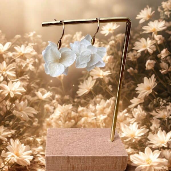 Les boucles Marisa dévoilent de véritables pétales d’hortensia blanc stabilisé suspendus à des crochets dorés. Un bijou délicat, aérien et 100 % naturel.