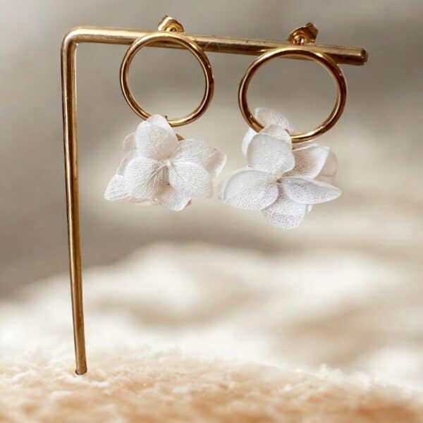 Les boucles Lily dévoilent de véritables pétales d’hortensia blanc stabilisé suspendus à des couronnes dorées. Un bijou délicat, aérien et naturel.
