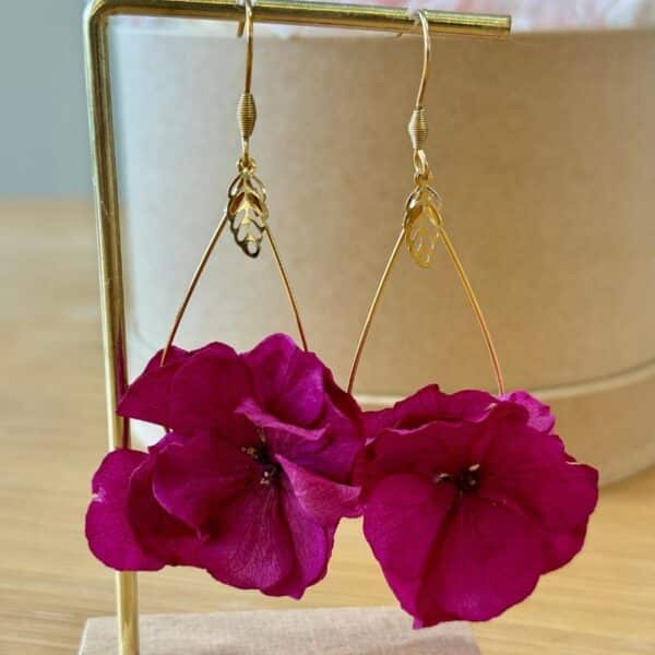 Audacieuses et vibrantes, les boucles d’oreilles Côme révèlent toute la beauté de l’hortensia fuchsia. Une création florale intense et lumineuse, pensée pour celles qui aiment affirmer leur style avec élégance.