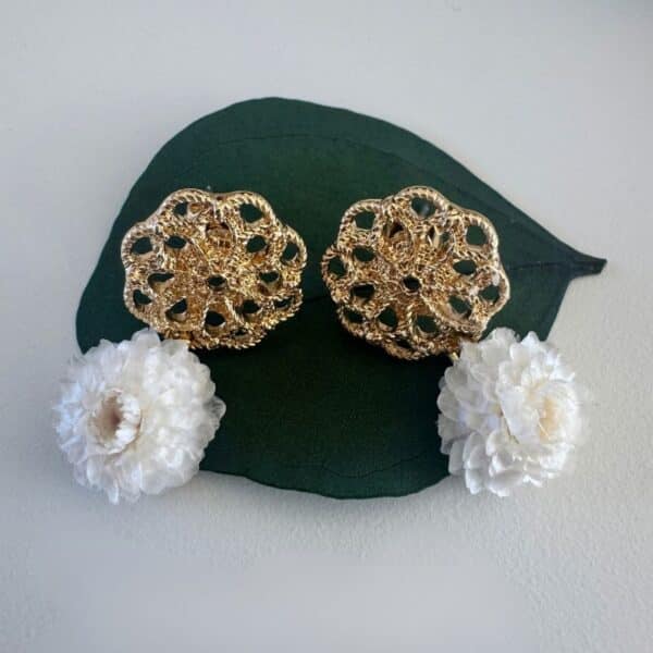 Les boucles d’oreilles Valentine associent un délicat médaillon doré ajouré à de véritables immortelles blanches stabilisées. Un bijou floral élégant et lumineux, imaginé pour les femmes qui aiment les créations délicates, naturelles et intemporelles.