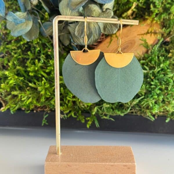 Les boucles d’oreilles Zélie associent la douceur de véritables feuilles d’eucalyptus stabilisées à l’éclat d’une finition dorée. Une création végétale originale et élégante, au style naturel et contemporain, parfaite pour apporter une touche de caractère à une tenue.