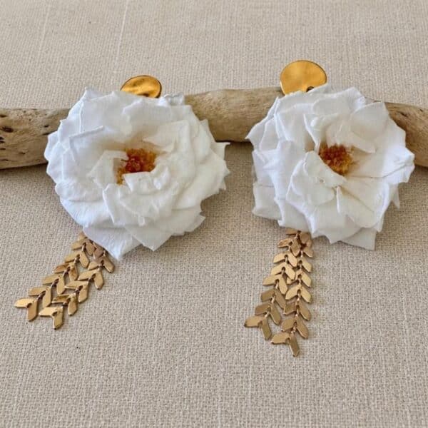 Les boucles d’oreilles Amélia associent de délicates roses sauvages blanches stabilisées à de jolies pampilles dorées. Une création florale élégante et féminine, à la fois romantique et contemporaine, idéale pour une mariée ou pour sublimer une tenue avec une touche de nature.