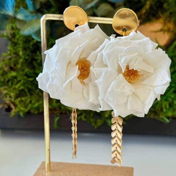 Les boucles d’oreilles Amélia associent de délicates roses sauvages blanches stabilisées à de jolies pampilles dorées. Une création florale élégante et féminine, à la fois romantique et contemporaine, idéale pour une mariée ou pour sublimer une tenue avec une touche de nature.