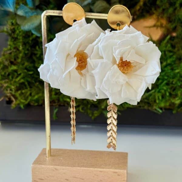 Les boucles d’oreilles Amélia associent de délicates roses sauvages blanches stabilisées à de jolies pampilles dorées. Une création florale élégante et féminine, à la fois romantique et contemporaine, idéale pour une mariée ou pour sublimer une tenue avec une touche de nature.