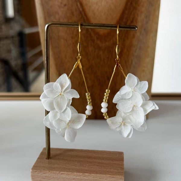 Les boucles d’oreilles Fanny dévoilent toute la délicatesse de l’hortensia blanc stabilisé dans une création aérienne et lumineuse.